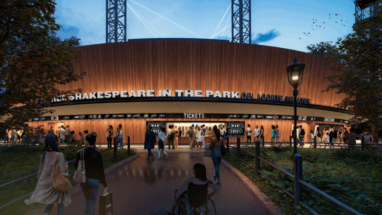 A crowd approaches the ticket area of the Delacorte Theater at dusk, with illuminated signage for Shakespeare in the Park and people entering, including a person using a wheelchair in the foreground.